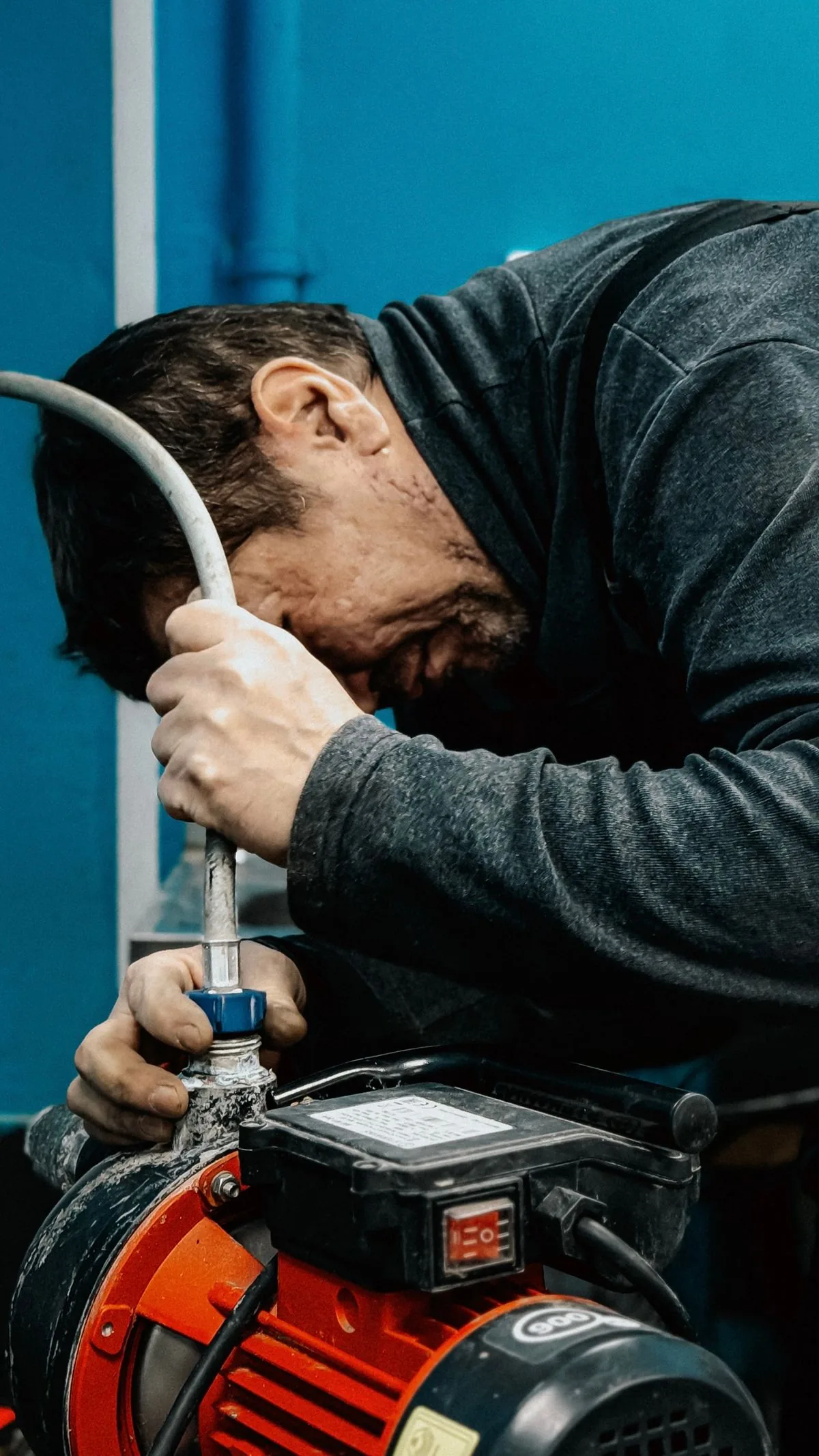 Técnico trabajando en una bomba de agua. Imagen de referencia para una marca ficticia.