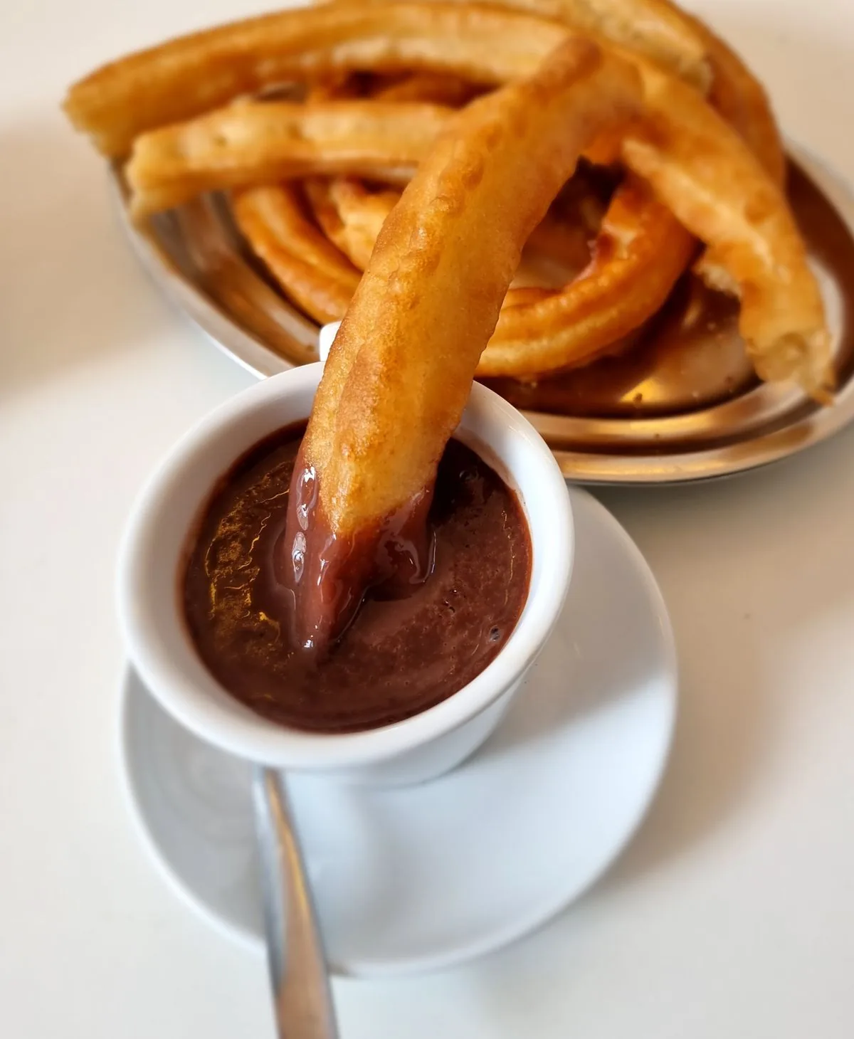 Churros acompañados de chocolate. Imagen de referencia para una marca ficticia.