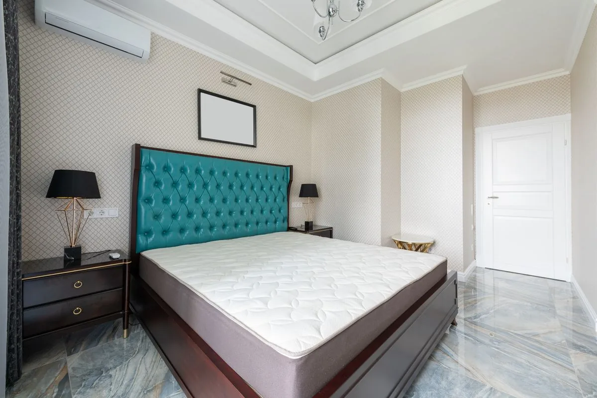 Cama con colchón en un interior de recámara. Imagen de referencia para una marca ficticia.