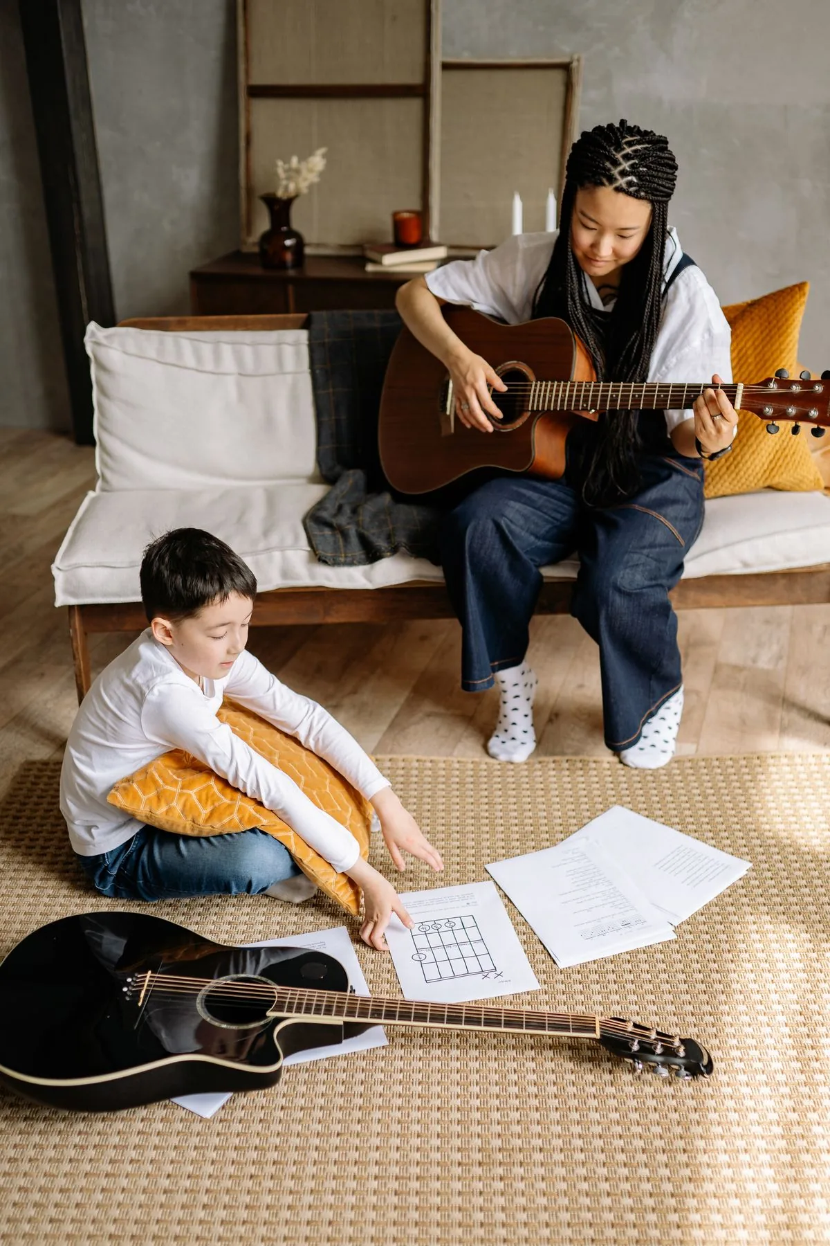 Clase de guitarra acompañada por un instructor. Imagen de referencia para una marca ficticia.