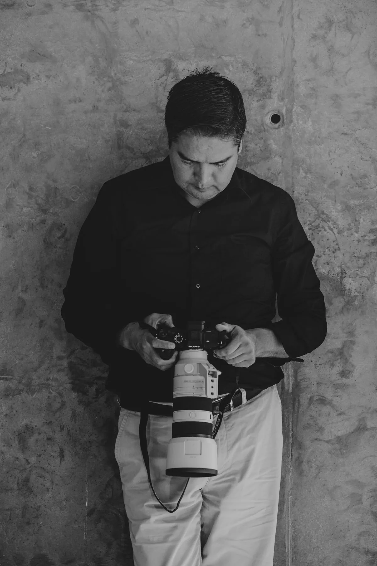 Fotógrafo sosteniendo su cámara. Imagen de referencia para una marca ficticia.