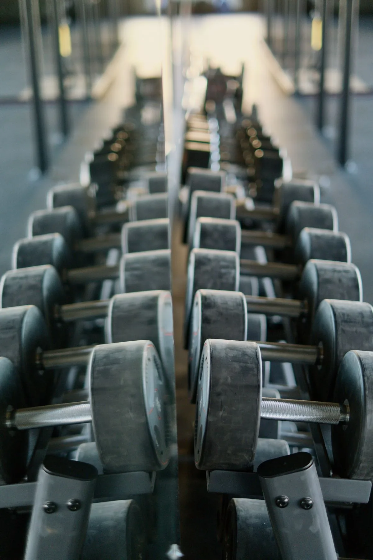 Mancuernas frente a un espejo de gimnasio. Imagen de referencia para una marca ficticia.