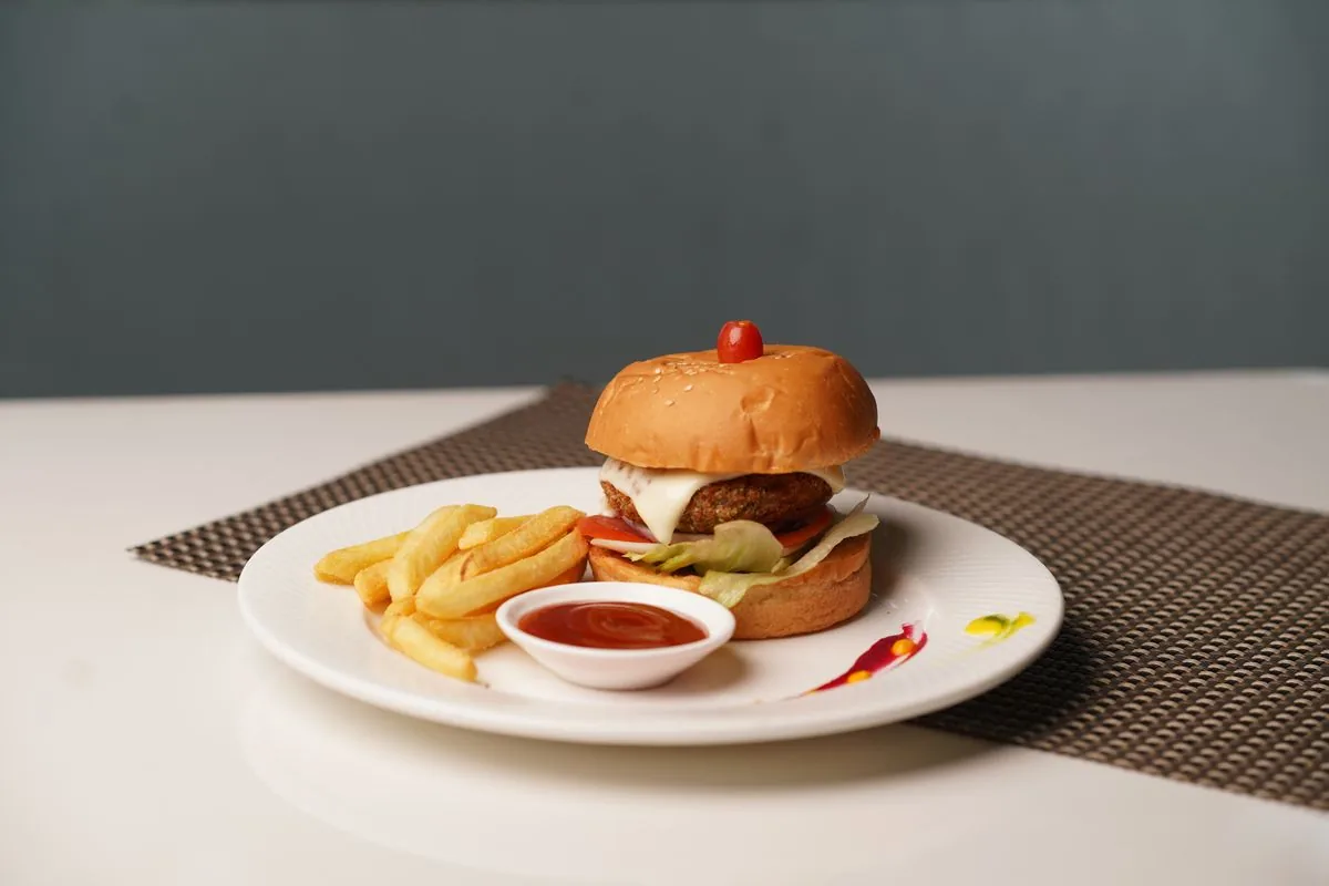 Hamburguesa con papas servida en un plato. Imagen de referencia para una marca ficticia.
