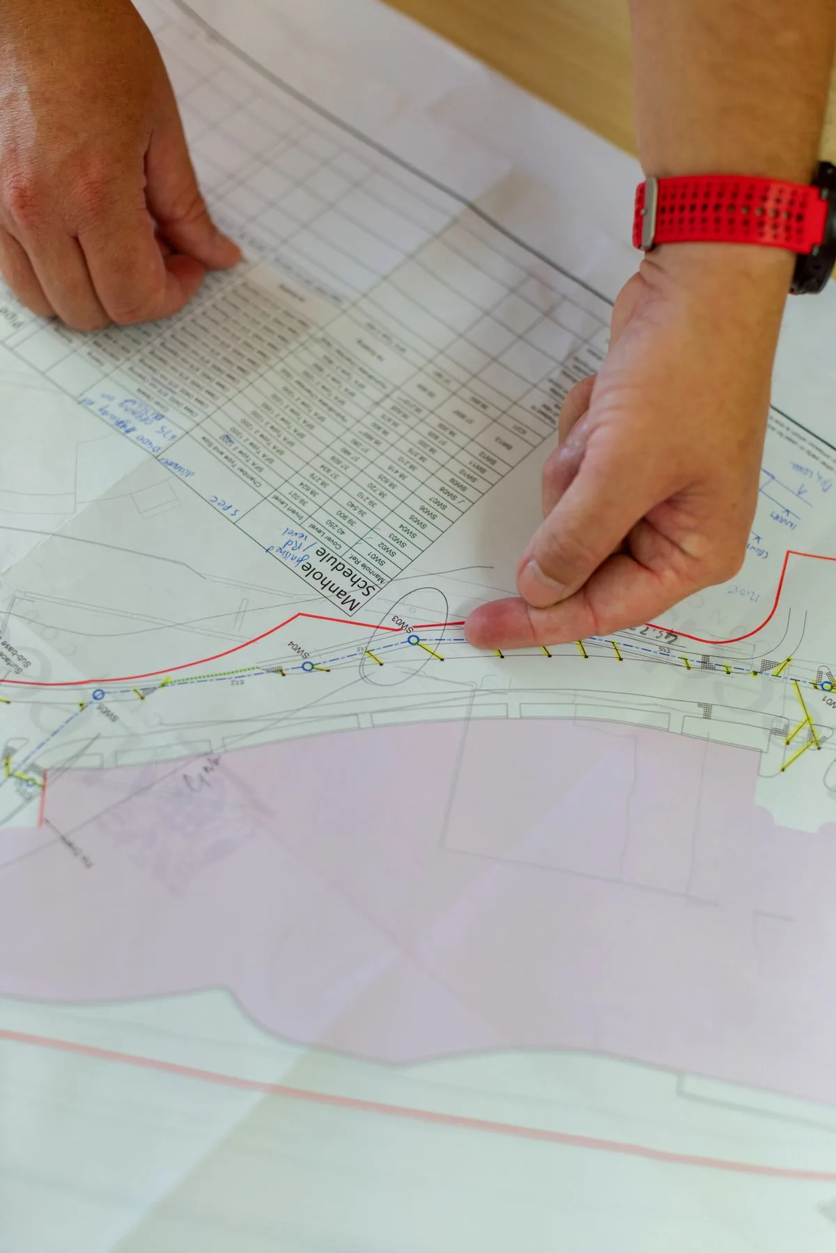 Profesional de ingeniería revisando un plano. Imagen de referencia para una marca ficticia.