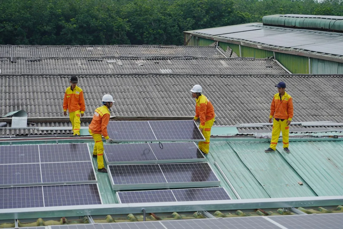 Técnicos instalando paneles solares en una azotea. Imagen de referencia para una marca ficticia.