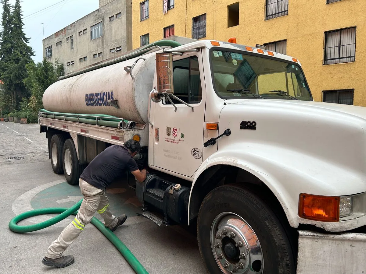 Trabajador junto a una pipa de suministro de agua. Imagen de referencia para una marca ficticia.