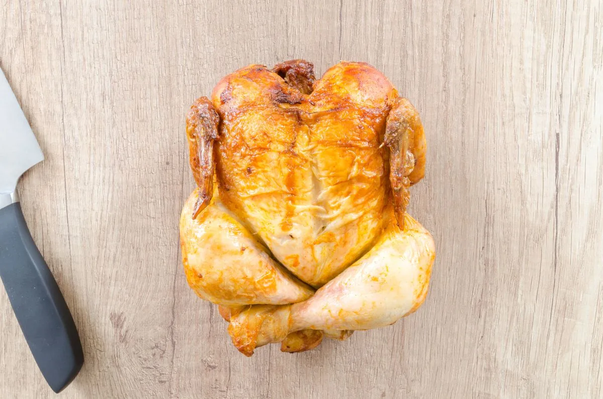 Pollo rostizado sobre una tabla. Imagen de referencia para una marca ficticia.