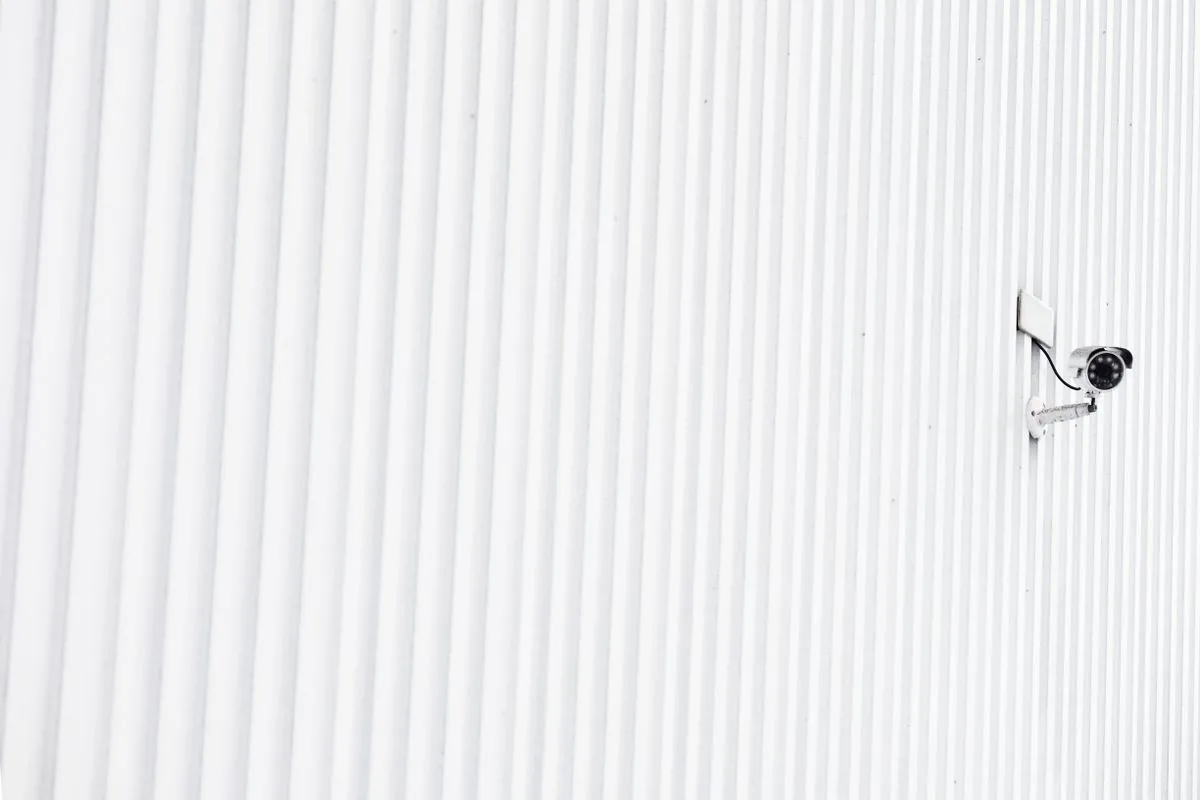 Cámara de videovigilancia instalada en una pared. Imagen de referencia para una marca ficticia.