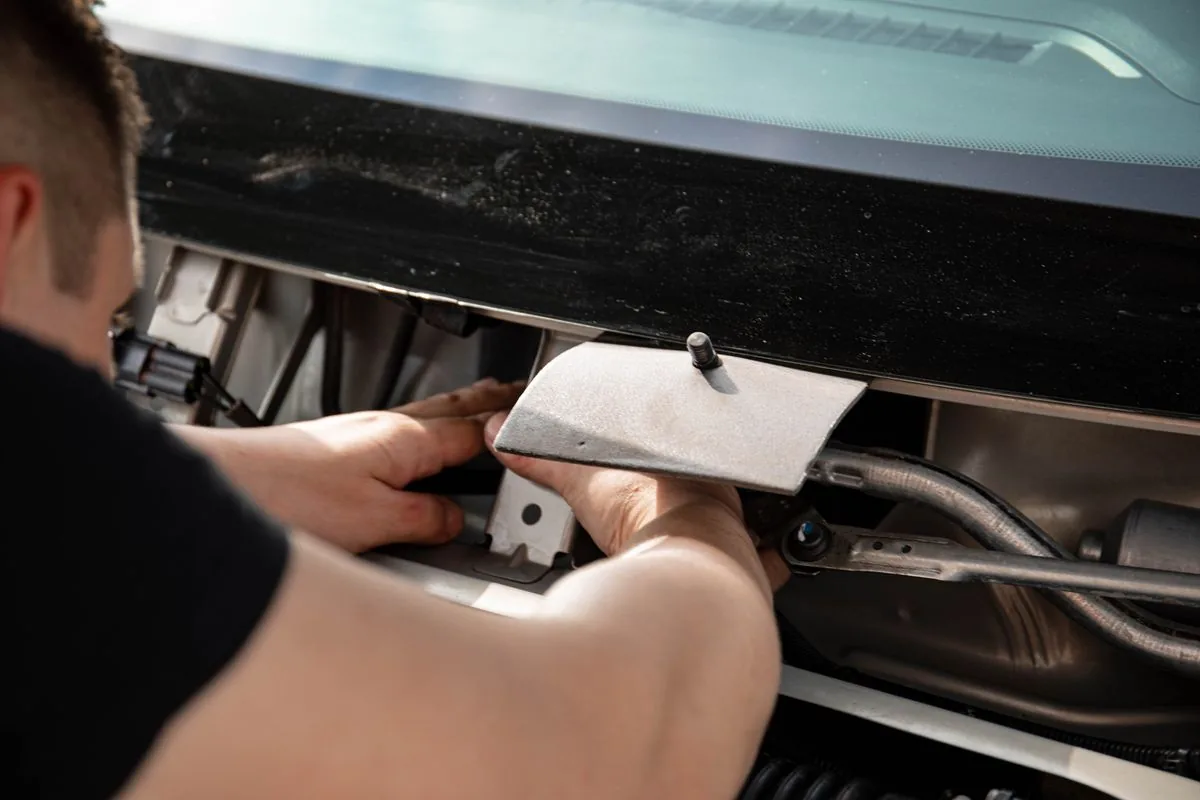 Mecánico trabajando en un automóvil. Imagen de referencia para una marca ficticia.