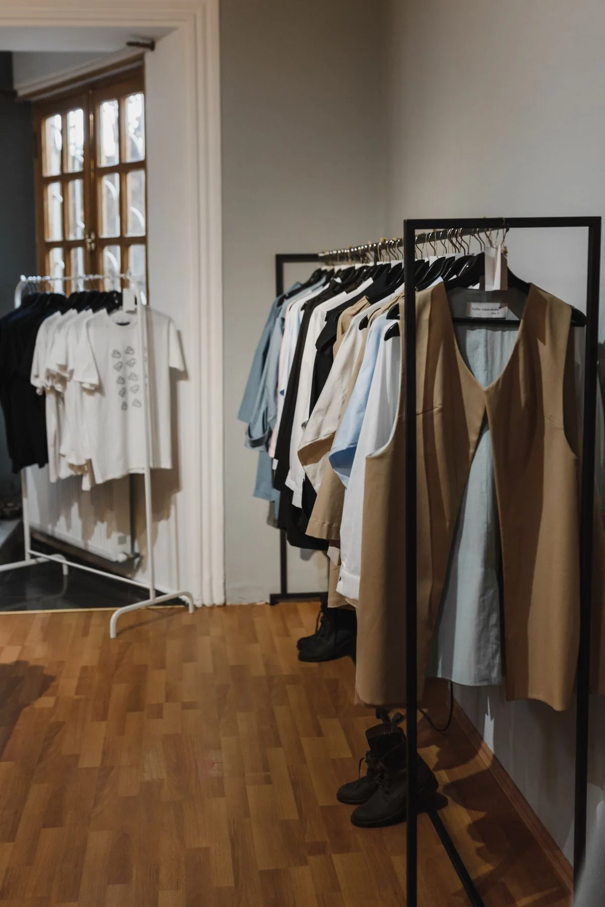 Prendas organizadas en los percheros de una boutique. Imagen de referencia para una marca ficticia.