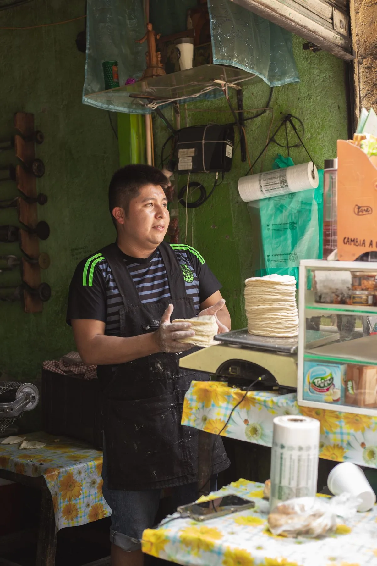 Trabajador preparando tortillas en un negocio de México. Imagen de referencia para una marca ficticia.