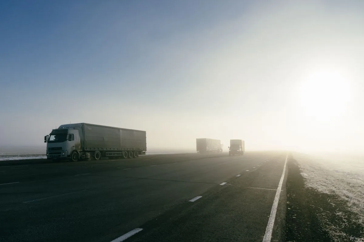 Unidades de transporte de carga circulando por una carretera. Imagen de referencia para una marca ficticia.