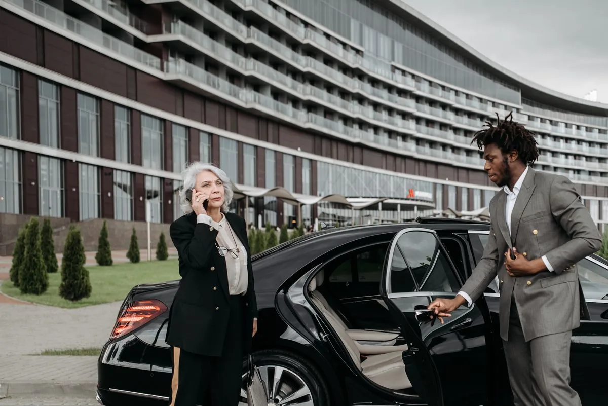 Conductor abriendo la puerta de un automóvil. Imagen de referencia para una marca ficticia.